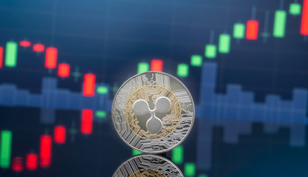 Ripple and cryptocurrency investing concept. A silver coin with XRP-s logo on it, in front of a chart showing a bullish pattern