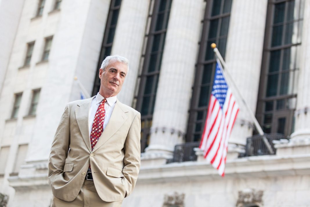 U.S. Customers to be Blocked from Trading on Binance.com A senior businessman standing in New York next to an American flag
