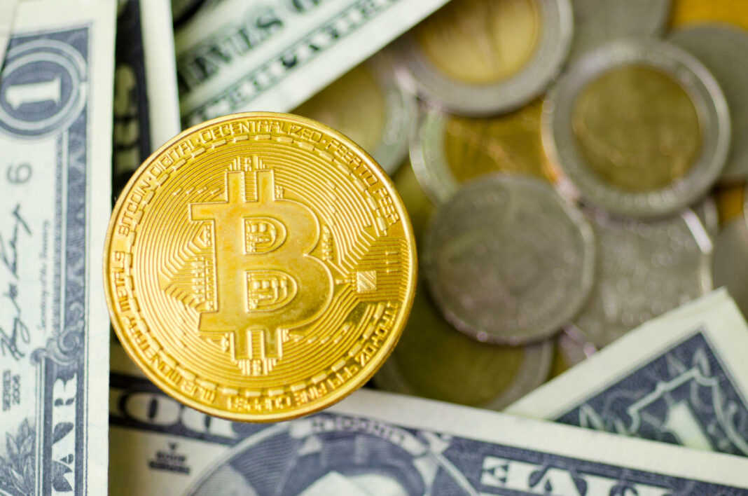 Bitcoin coin among dollar bills and coins