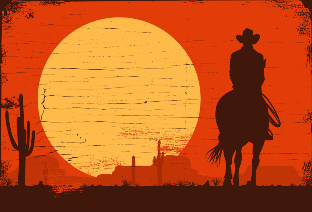 Cowboy riding in the desert at sunset