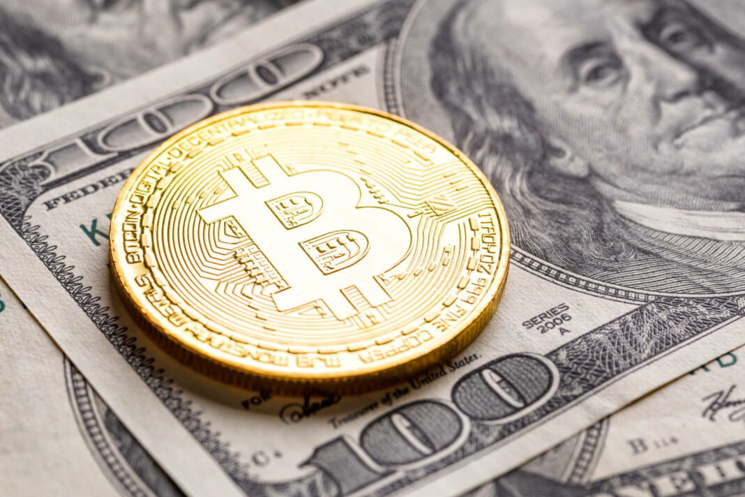 Bitcoin coin on top of a US dollar banknote