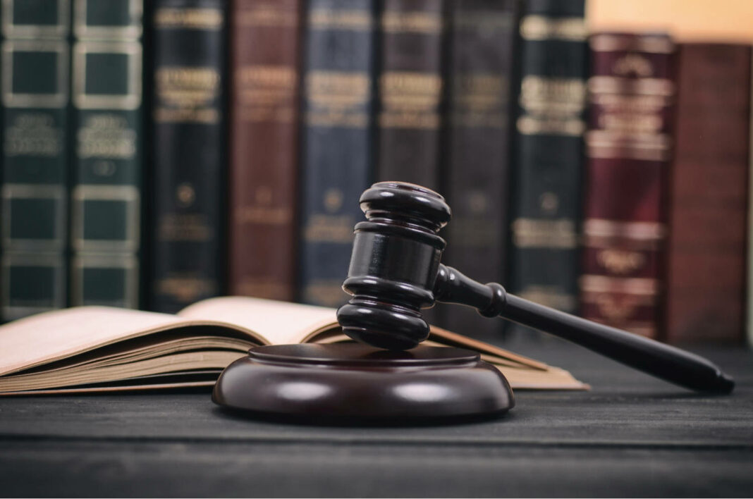 Judge Gavel and law book on a black wooden background