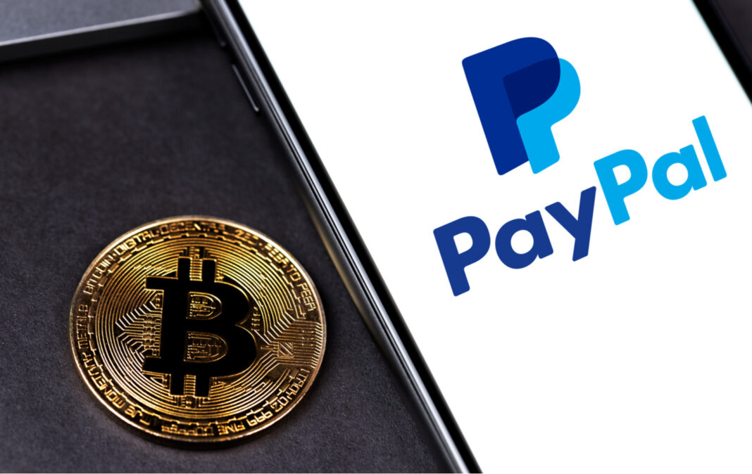 PayPal logo on the screen smartphone with bitcoin cryptocurrency